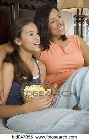 Hispanic mother and daughter watching television View Large Photo Image Stock Photography - Hispanic mother and daughter watching television. Fotosearch