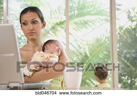 Hispanic mother holding baby View Large Photo Image Picture - Hispanic mother holding baby . Fotosearch