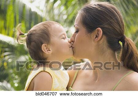 Stock Photo - Hispanic mother kissing baby. Fotosearch