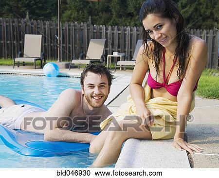 Stock Image - Middle Eastern couple in swimming pool. Fotosearch