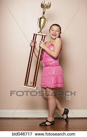 Stock Photo - Mixed Race girl holding dancing trophy. Fotosearch