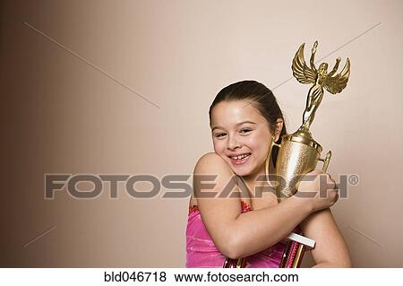 Stock Photo - Mixed Race girl holding dancing trophy. Fotosearch
