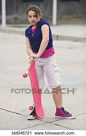 Mixed Race girl holding skateboard View Large Photo Image Stock Image - Mixed Race girl holding skateboard. Fotosearch