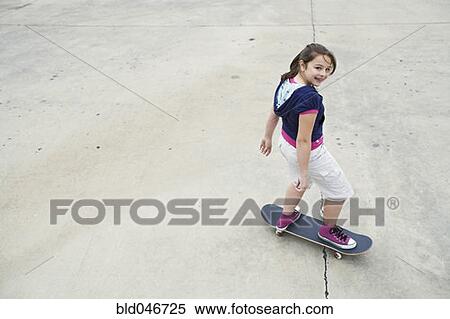 Stock Photography - Mixed Race girl riding skateboard. Fotosearch