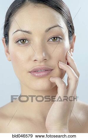 Mixed Race woman with hand on face View Large Photo Image Stock Photo - Mixed Race woman with hand on face. Fotosearch