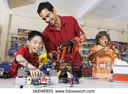 Stock Image - Multi-ethnic children playing at toy store. Fotosearch
