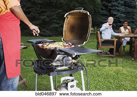 Stock Photo - Multi-ethnic friends having barbecue. Fotosearch