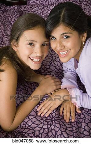Stock Photo - Multi-ethnic girls touching heads. Fotosearch