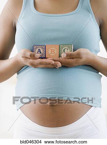 Pregnant African American woman holding ABC blocks View Large Photo Image Picture - Pregnant African American woman holding ABC blocks. Fotosearch