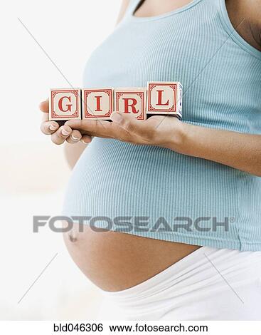 Stock Photograph - Pregnant African American woman holding “GIRL” blocks. Fotosearch