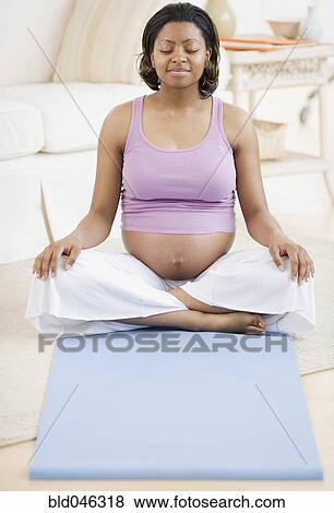 Stock Photo - Pregnant African American woman practicing yoga. Fotosearch