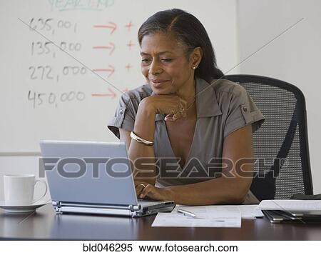 Senior African American businesswoman looking at laptop View Large Photo Image Stock Photography - Senior African American businesswoman looking at laptop. Fotosearch