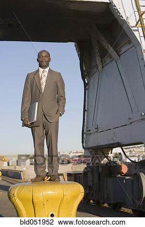 Stock Image - African American businessman holding laptop. Fotosearch
