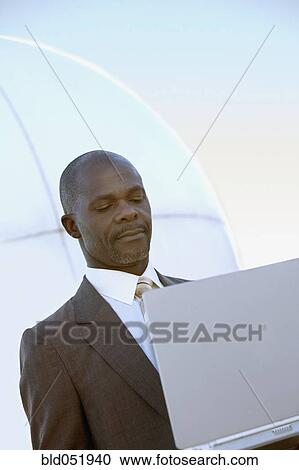 African American businessman looking at laptop View Large Photo Image Stock Image - African American businessman looking at laptop. Fotosearch
