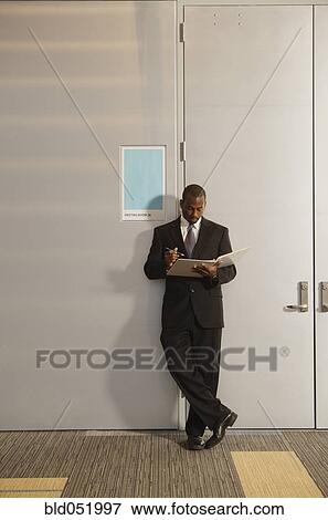 Stock Photo - African American businessman looking at paperwork. Fotosearch