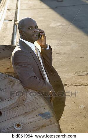 Picture - African American businessman talking on cell phone. Fotosearch