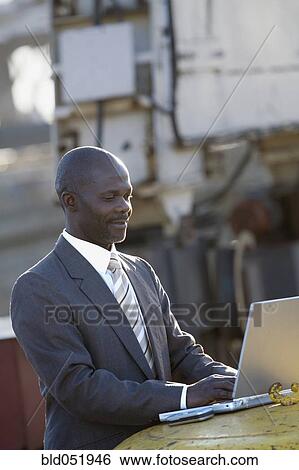 Stock Photograph - African American businessman typing on laptop. Fotosearch
