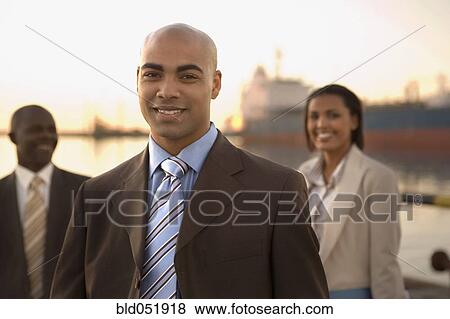 Stock Photo - African American businesspeople in front of freighter. Fotosearch