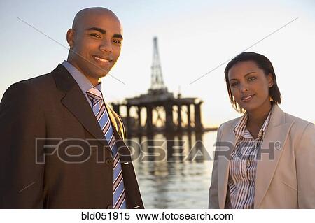 Stock Photography - African American businesspeople in front of shipping crane. Fotosearch
