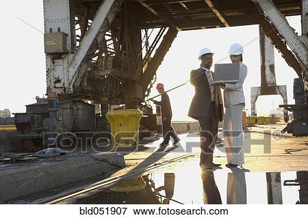 Stock Photo - African American businesspeople wearing hardhats. Fotosearch