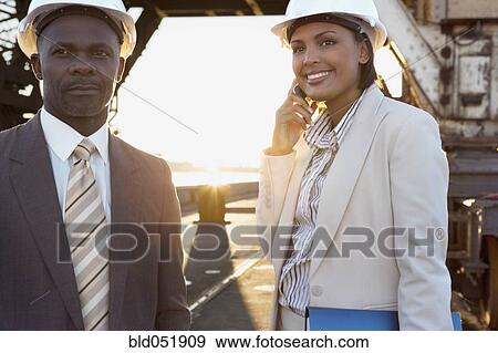 Stock Photo - African American businesspeople wearing hardhats. Fotosearch