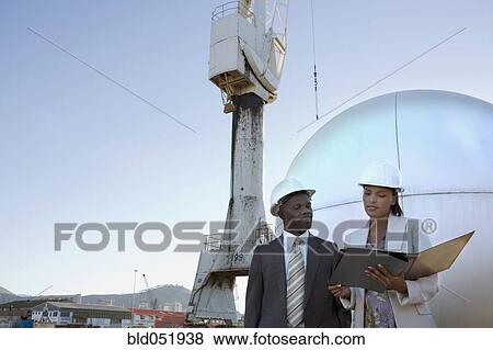 Stock Photo - African American businesspeople wearing hardhats. Fotosearch