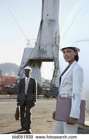 Stock Photo - African American businesspeople wearing hardhats. Fotosearch