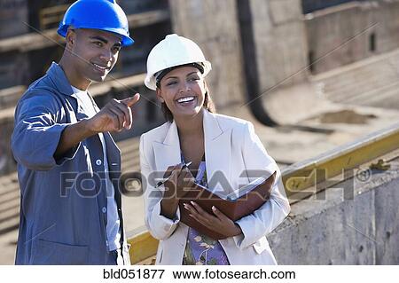 African American businesswoman and construction worker pointing View Large Photo Image Stock Photo - African American businesswoman and construction worker pointing. Fotosearch