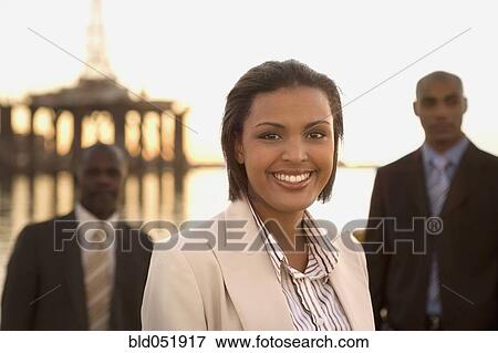 Stock Photo - African American businesswoman in front of businessmen. Fotosearch