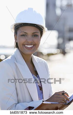 Stock Image - African American businesswoman wearing hardhat. Fotosearch