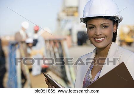 Stock Photography - African American businesswoman wearing hardhat. Fotosearch