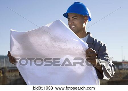 Stock Image - African American construction worker holding blueprints. Fotosearch