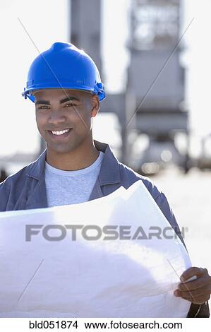 African American male construction worker holding blueprints View Large Photo Image Picture - African American male construction worker holding blueprints. Fotosearch