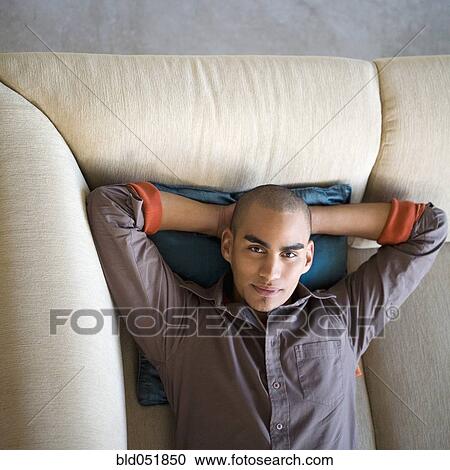 African American man laying on sofa View Large Photo Image Stock Image - African American man laying on sofa. Fotosearch