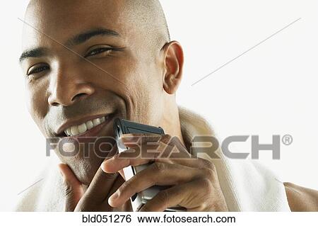 African American man shaving face with electric razor View Large Photo Image Stock Photograph - African American man shaving face with electric razor. Fotosearch