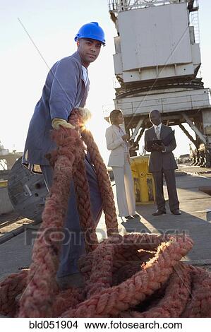 Picture - African American manual worker pulling rope. Fotosearch