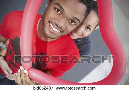 Stock Photo - African couple holding heart-shaped balloon. Fotosearch