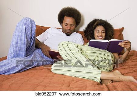 Stock Photo - African couple reading in bed. Fotosearch