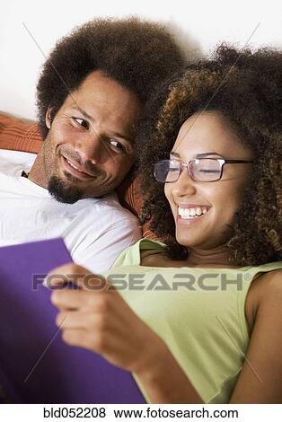 Stock Photo - African couple reading in bed. Fotosearch