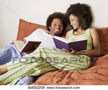 Stock Photo - African couple reading in bed. Fotosearch