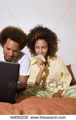 Stock Image - African couple shopping online. Fotosearch