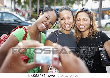 Stock Photography - African friends having photograph taken. Fotosearch