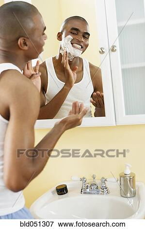 Stock Photo - African man applying shaving cream. Fotosearch