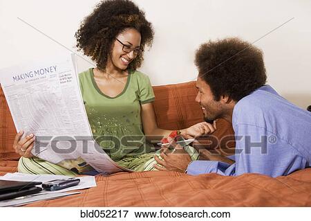 Stock Photo - African man bringing strawberries to wife in bed. Fotosearch