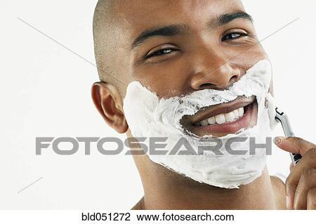 Stock Image - African man shaving face. Fotosearch
