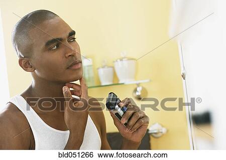 African man shaving with electric razor View Large Photo Image Stock Photograph - African man shaving with electric razor. Fotosearch