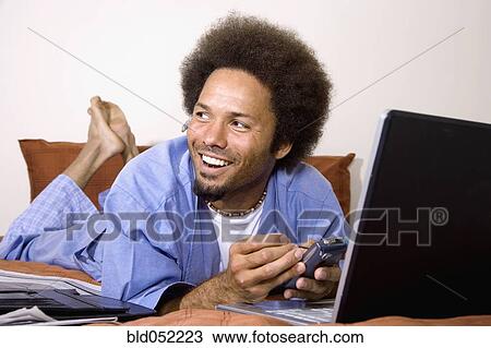 Stock Image - African man using electronic organizer. Fotosearch