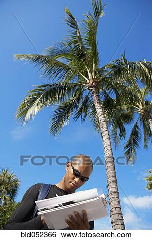 Stock Photograph - African man writing on clipboard. Fotosearch