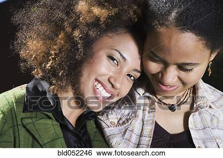 Stock Photograph - African sisters hugging. Fotosearch