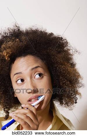 Stock Image - African woman brushing teeth. Fotosearch